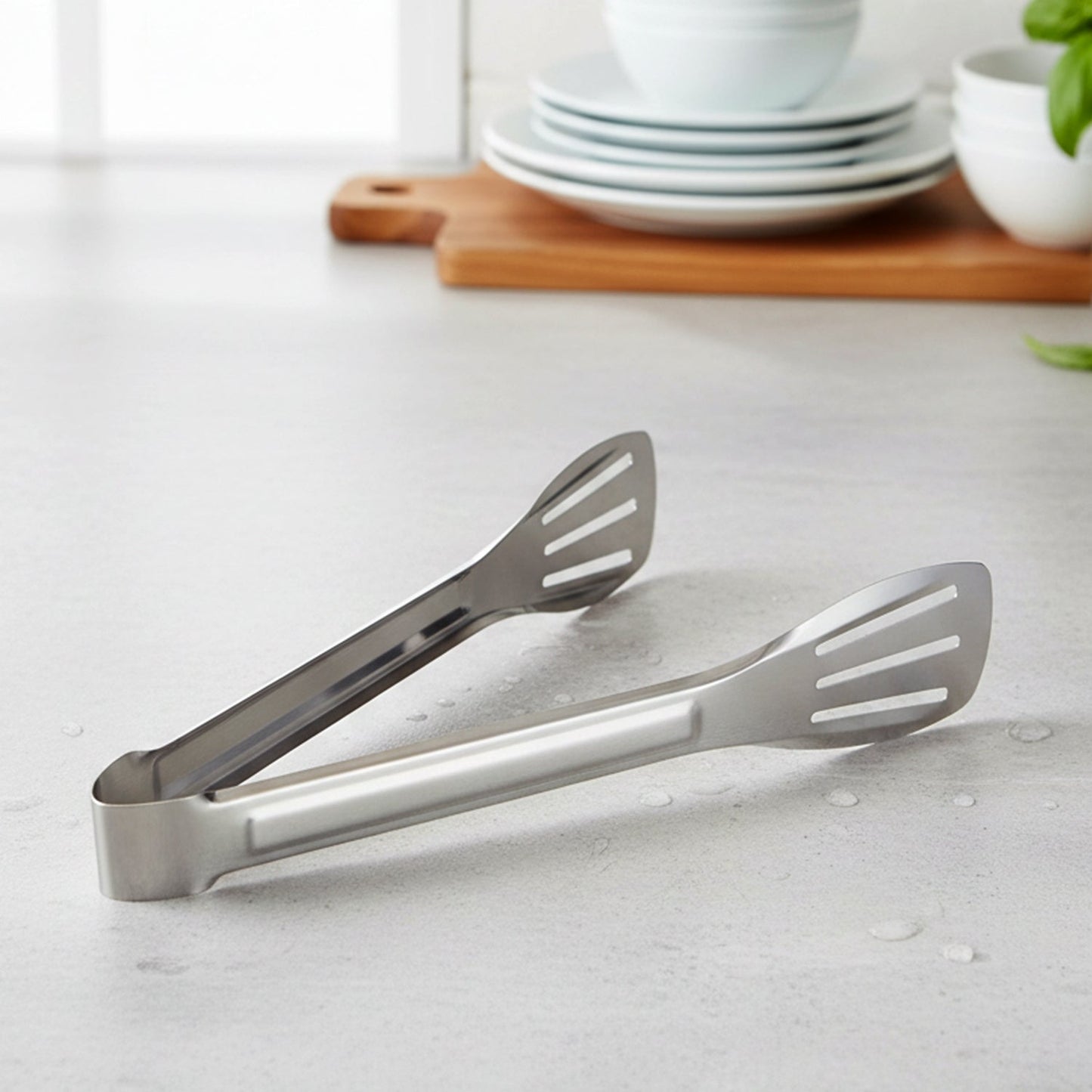 Serving tongs laid next to plates, ideal for serving snacks and salads