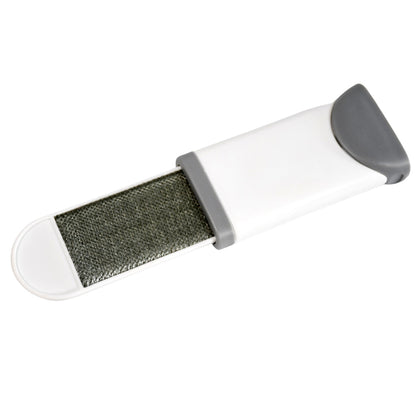 Lint remover brush effectively picking up pet fur from an upholstered couch.