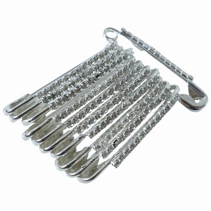 Multiple silver safety pins from the 12-piece decorative brooch set