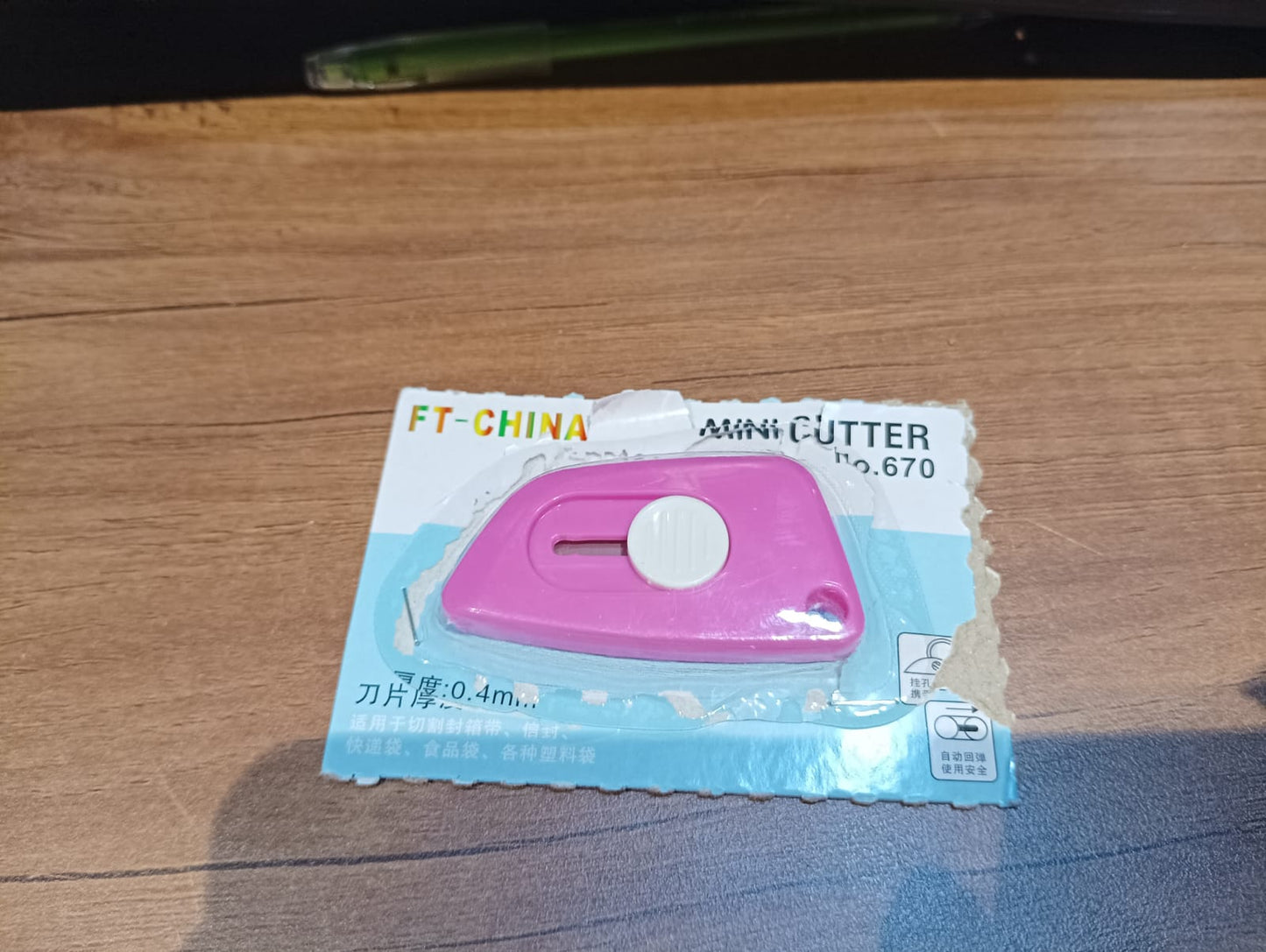 Mini Cloud Cutter retractable utility knife displayed on wooden surface with its packaging