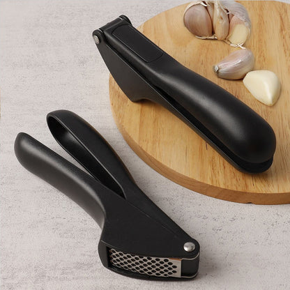 Handheld garlic mincer tool ready for crushing fresh garlic cloves