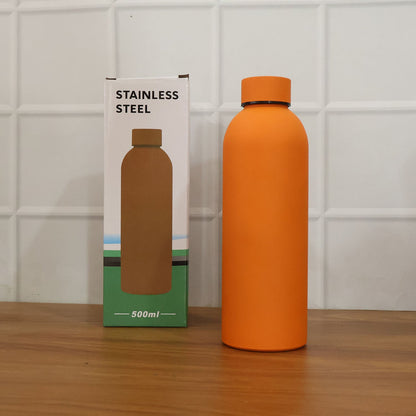 Lifestyle image featuring stainless steel insulated orange water bottle