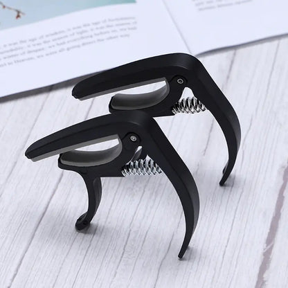 Wagtail guitar capo showcasing its pick holder and soft stand features.